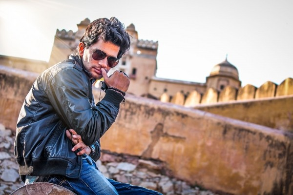portrait-of-man-in-sunglasses-sitting-in-front-of-castle