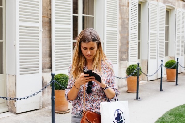 young-woman-text-messaging-on-street