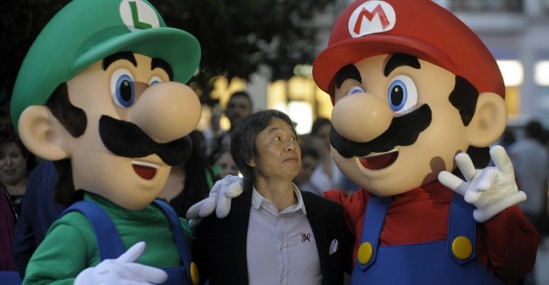 Japanese video game designer Shigeru Miyamoto (C) poses with arcade game stars Mario Bros and Luigi at the Jovellanos Theatre in Gijon, on October 25, 2012, to participate in a tribute to the video game, on the eve of the Prince of Asturias 2012 Award ceremony. Miyamoto has been awarded with the Prince of Asturias Award for Communication and Humanities. AFP PHOTO/ MIGUEL RIOPA