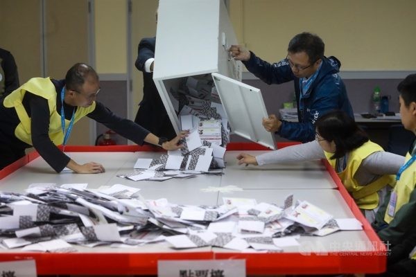 香港近日抗爭情勢逐漸趨緩，24日區議會選舉如期舉行，晚間10時30分結束投票後進行點票作業，灣仔一家投票站工作人員將選票倒入點票檯上。圖片來源：中央社記者吳家昇攝