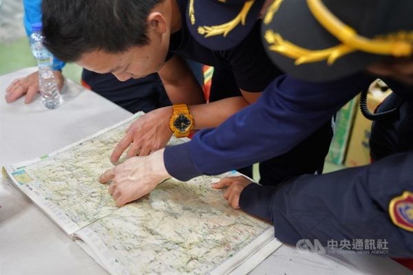 搜救人員緊急在烏來分隊集結，利用地圖研究搜救路線。中央社記者