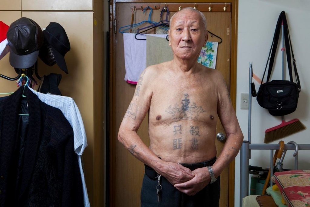 韓戰戰俘田子英站在房間內，赤裸上身，肚子上有著「殺盡共匪」四字。