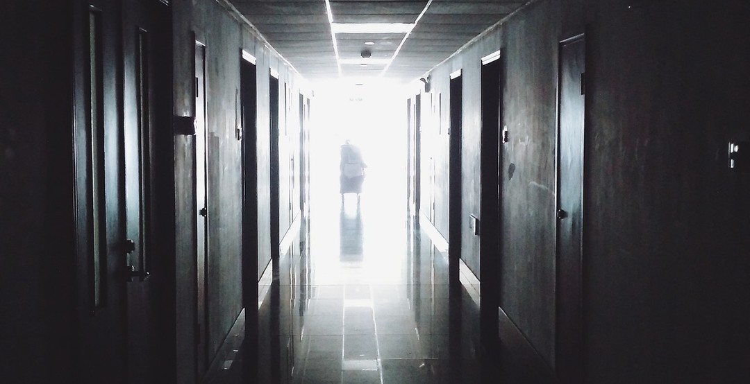 灰暗的醫院走道，走廊的深處傳來光